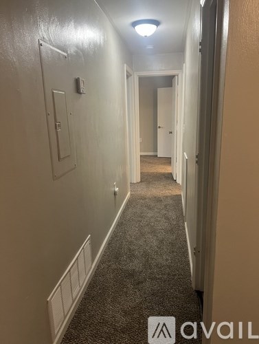 A long hallway with a carpeted floor and white walls.