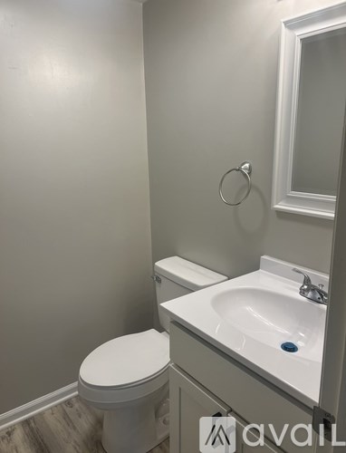 A white toilet sits next to a white sink in a bathroom.