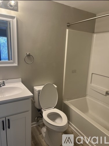 A bathroom with a toilet, sink, and bathtub.