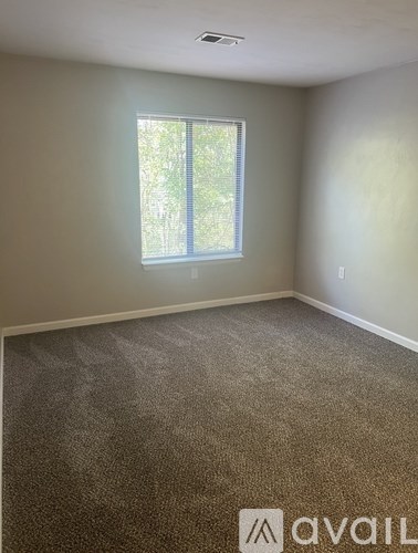 A room with a carpeted floor and a window.