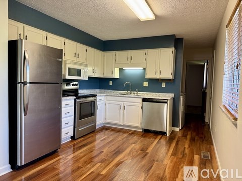 A kitchen with a refrigerator, oven, and sink.
