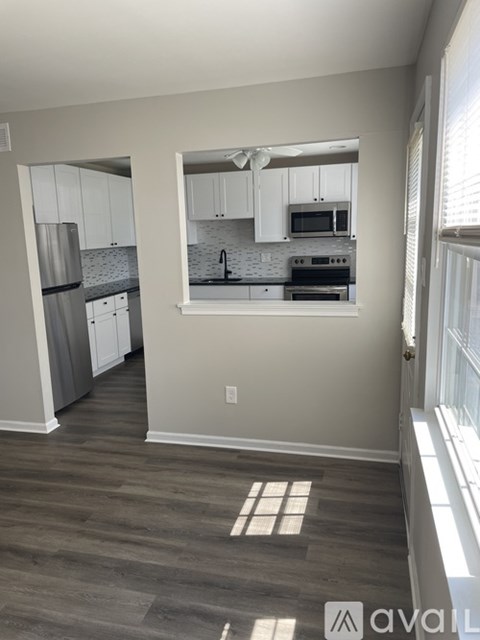 A kitchen with white cabinets and a refrigerator.