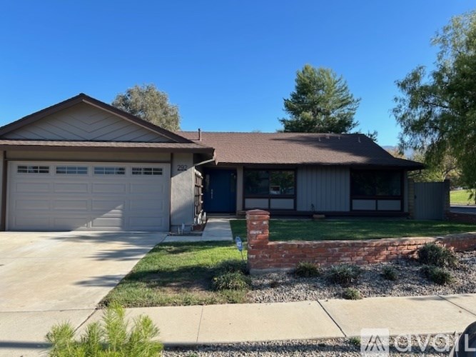 A house with a garage and a brick pillar in front.