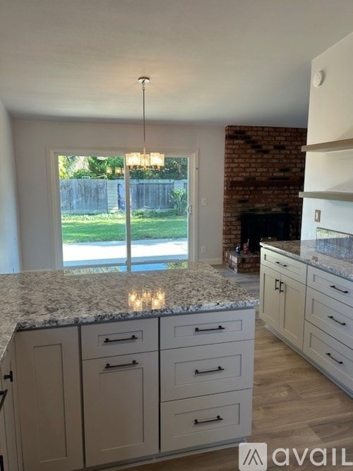 A kitchen with granite countertops and white cabinets.