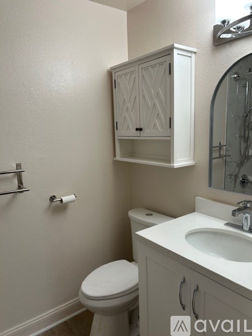 A white toilet sits next to a sink in a bathroom.