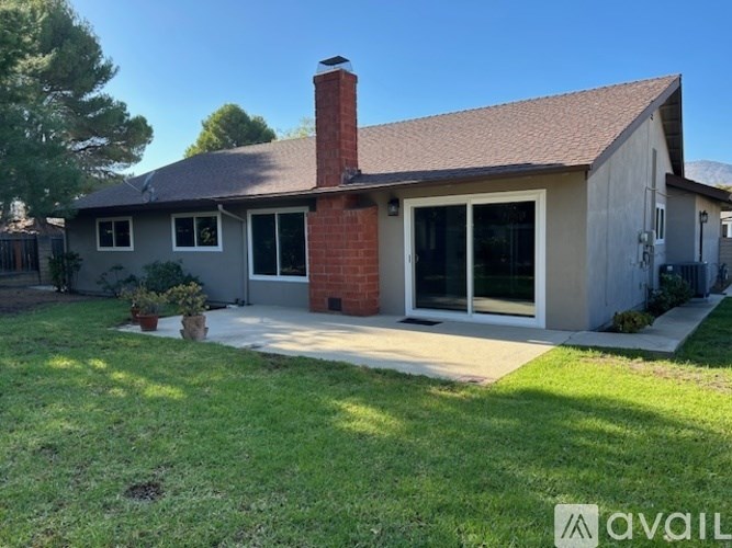 A house with a brown roof and a brick chimney is for sale.