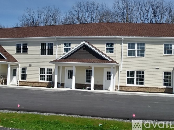 A two-story building with a brown roof and white trim is available for purchase.