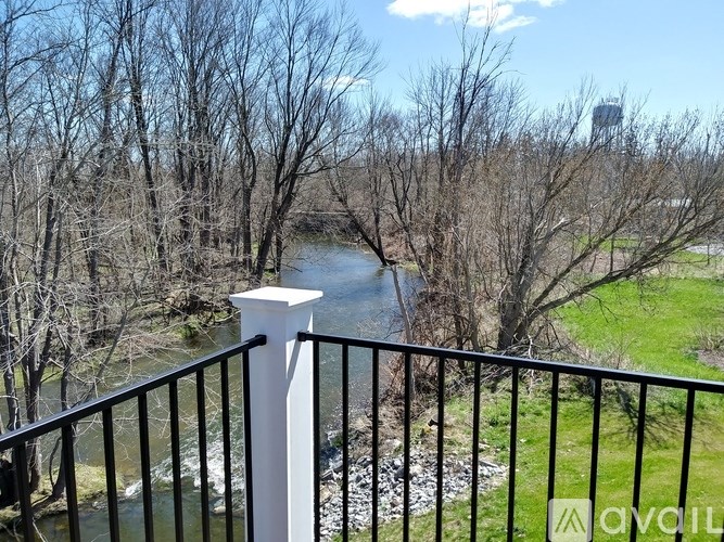 A white pillar on a balcony overlooks a river.
