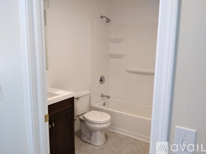 A white toilet sits in a bathroom next to a white sink.
