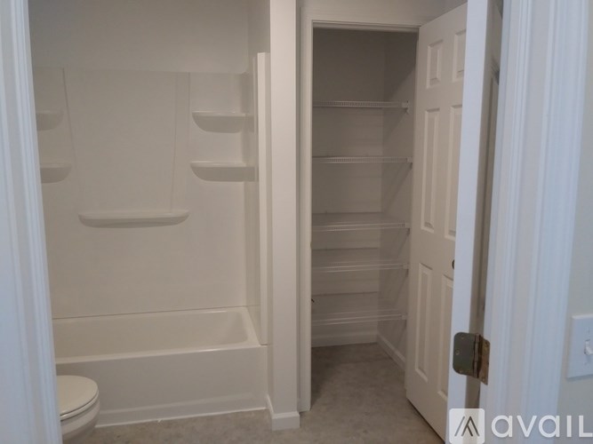 A white bathroom with a toilet and a walk in shower.