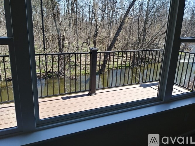 A balcony with a railing overlooking a body of water and trees.