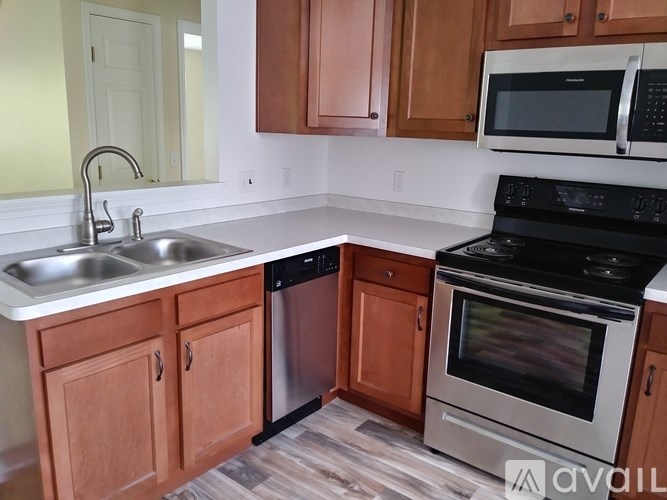 A kitchen with wooden cabinets and a black stove top oven.