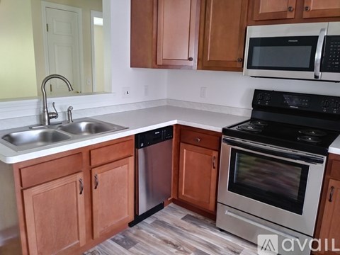 A kitchen with wooden cabinets and a black stove top oven.