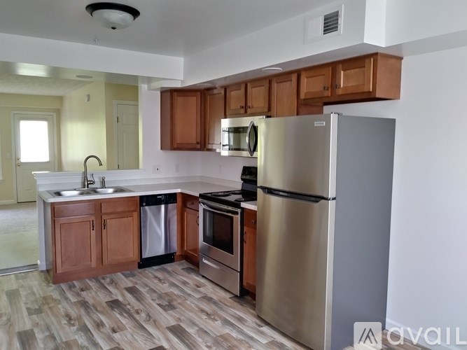 A kitchen with a refrigerator, sink, and oven.