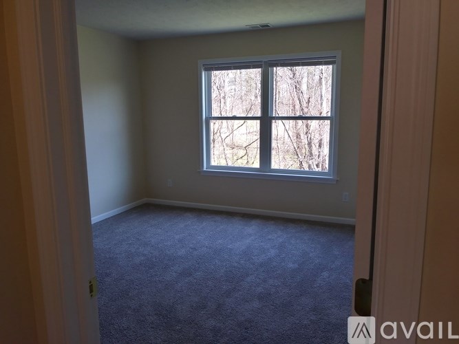A room with a carpeted floor and a window.
