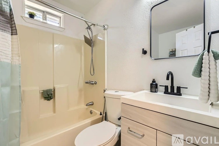 A bathroom with a toilet, sink, and shower.