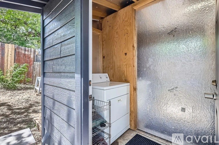 A small outdoor kitchen area with a refrigerator and a dishwasher.