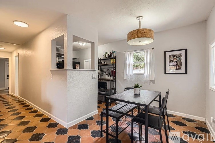 A dining room with a black table and chairs.