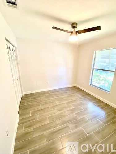 A room with a ceiling fan and a window.