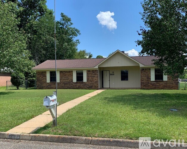 A house with a brick facade and a mailbox in front.