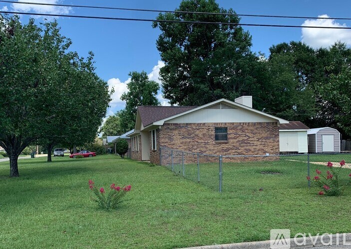 A house with a fence and a tree in front of it.