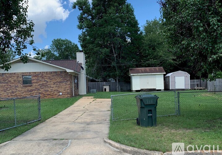 A house with a driveway and a green trash can.