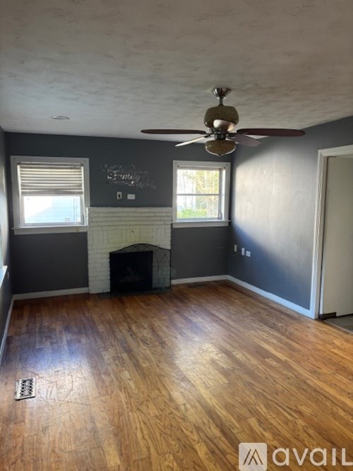 A room with a fireplace and a ceiling fan.