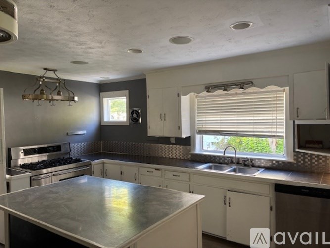 A kitchen with a stove top oven and a sink.