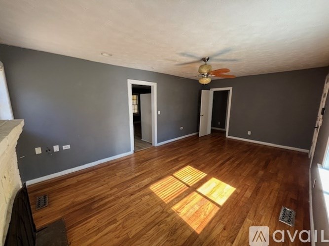 A room with wooden floors and a ceiling fan.