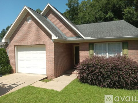 A house with a white garage door and a brick facade.