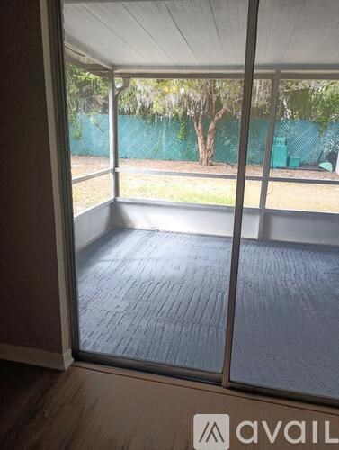 A patio with a sliding glass door leading to a backyard.