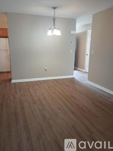 A room with wooden flooring and a hanging light fixture.