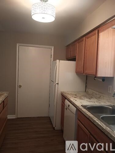 A kitchen with wooden cabinets and a white refrigerator.