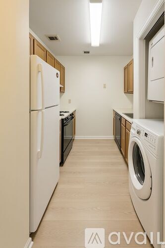 A kitchen with a white fridge and a washing machine.