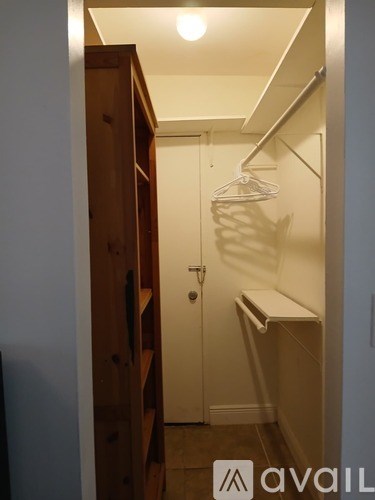 A small closet with a white door and a hanger.