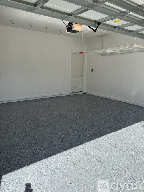 A spacious room with a grey floor and white walls.