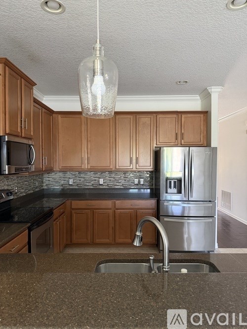 A kitchen with wooden cabinets and a granite countertop.
