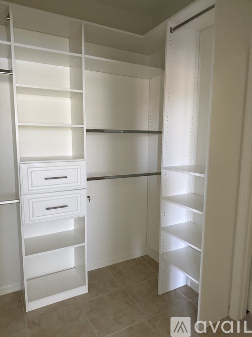 A white shelving unit with drawers is in a room with beige tiles.