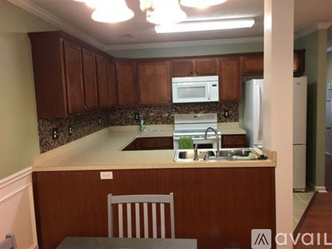 A kitchen with brown cabinets and a white fridge.