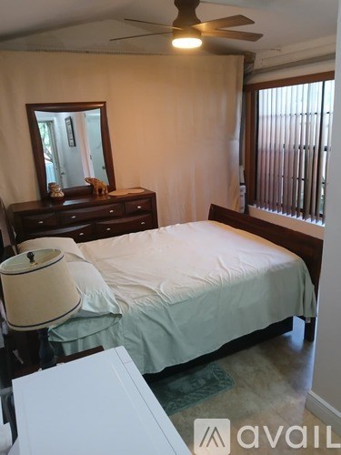 A bedroom with a bed, dresser, and mirror.