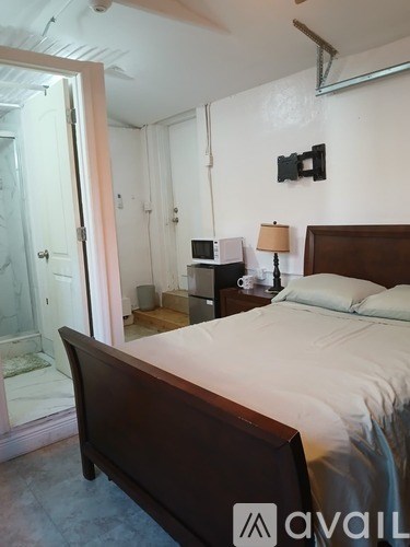 A bedroom with a large bed and a television on the wall.