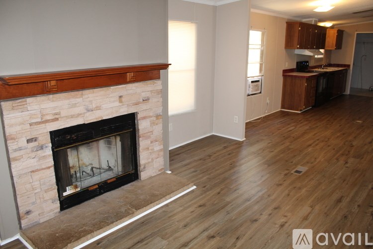 A room with a fireplace and wooden flooring.