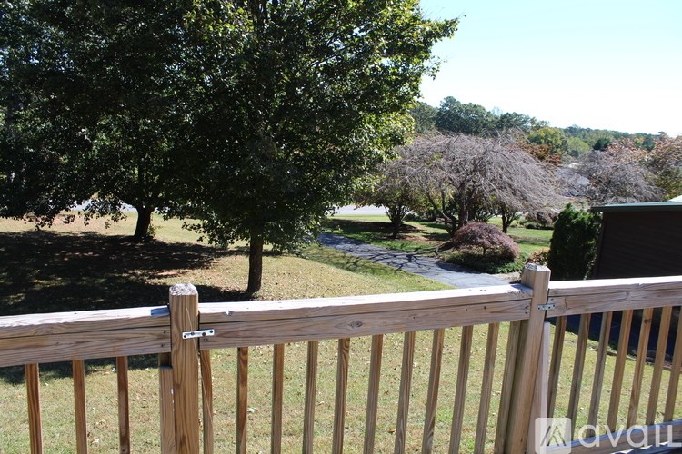 A wooden fence in front of a tree and a house.
