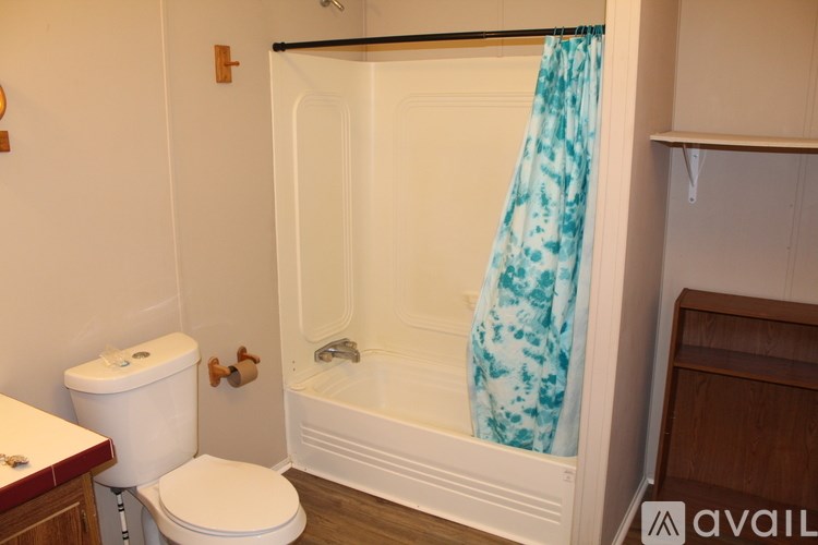 A white toilet sits next to a white bathtub in a bathroom.