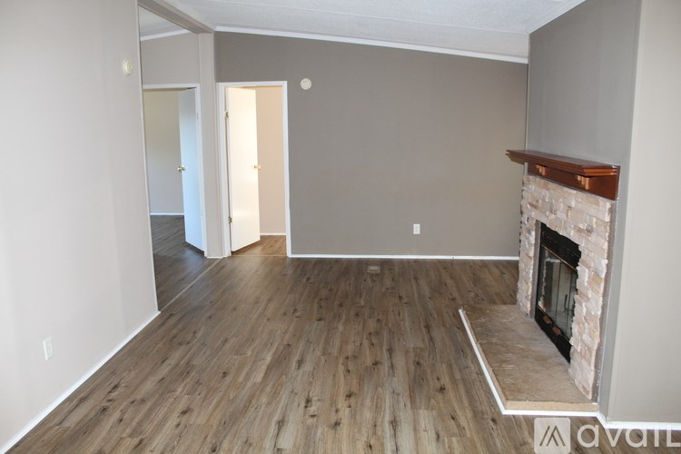 A living room with a fireplace and wood flooring.