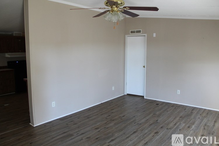 A room with a ceiling fan and a door.