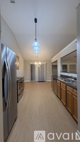 A kitchen with wooden floors and stainless steel appliances.