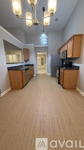 A kitchen with wooden cabinets and a black countertop.