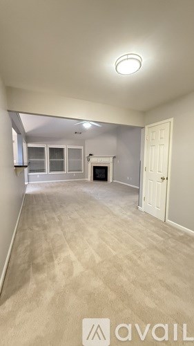 A room with a carpeted floor and a door on the right side.