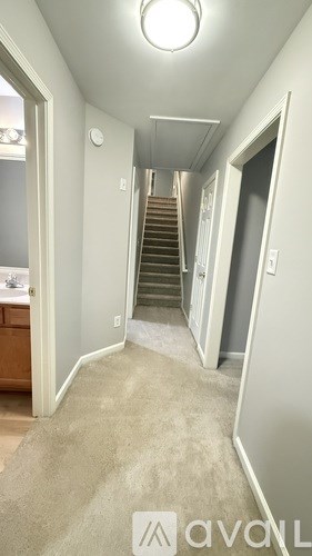 A hallway with a staircase leading to the second floor.
